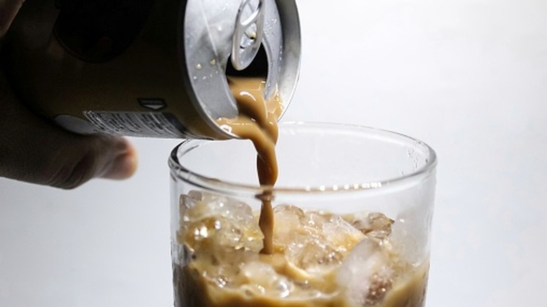 pouring canned coffee into a glass