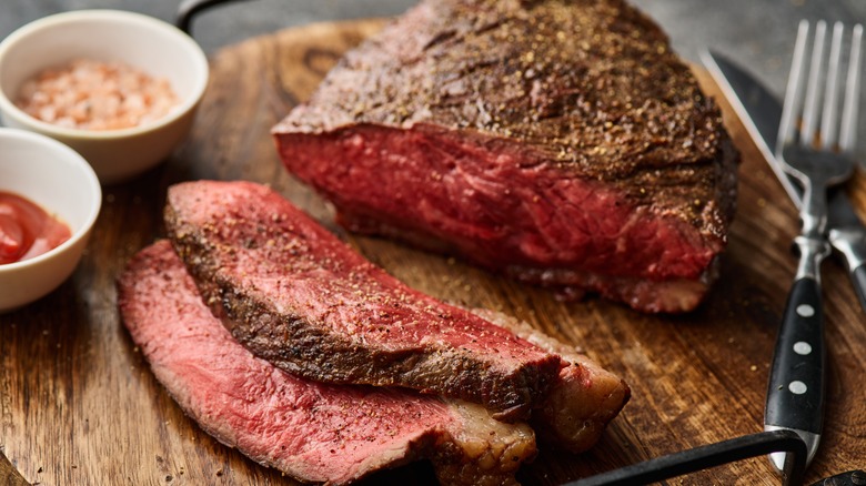 Sliced steak on wood board