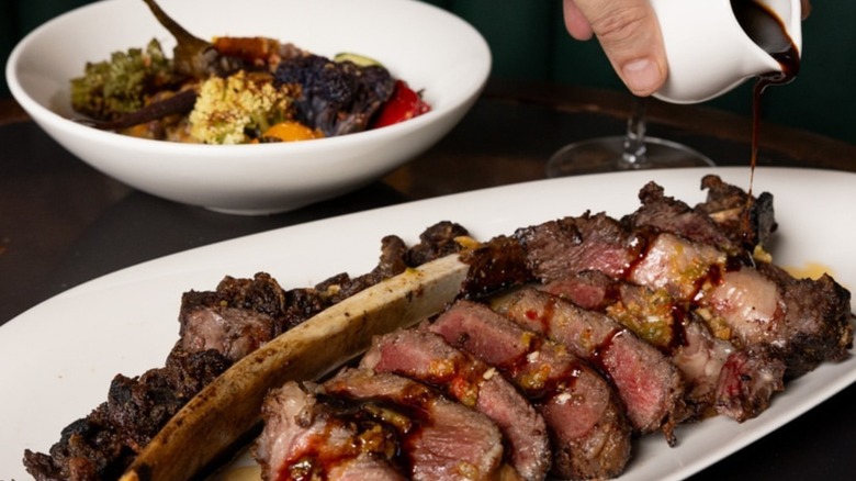 wine sauce poured on cooked steak