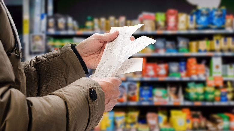 person holding receipts in store