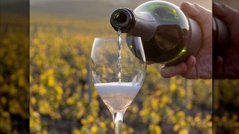 Champagne pouring from a bottle into a flute outside