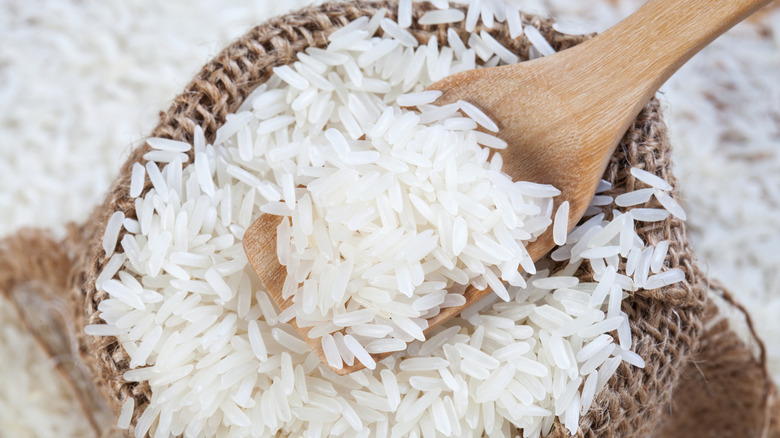 uncooked rice with wooden spoon