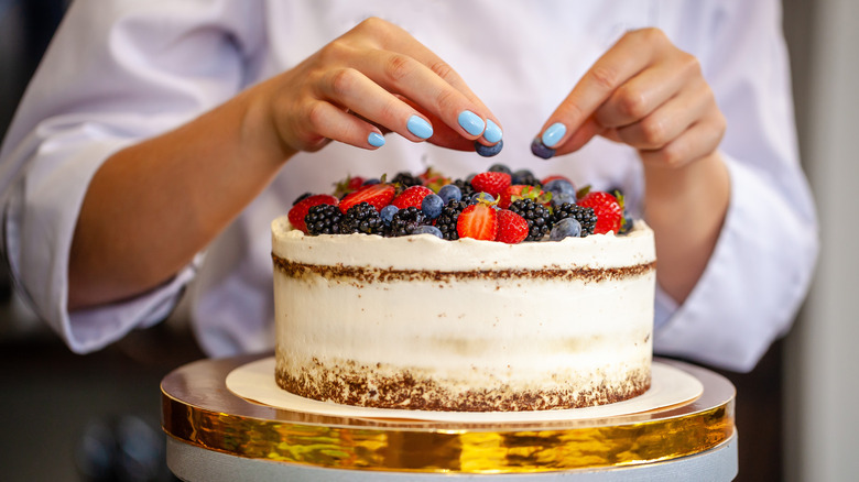 baker decorating cake