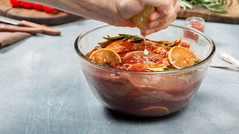 squeezing lemon over marinating meat