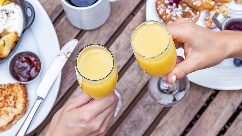 Mimosa glass held in hand at restaurant