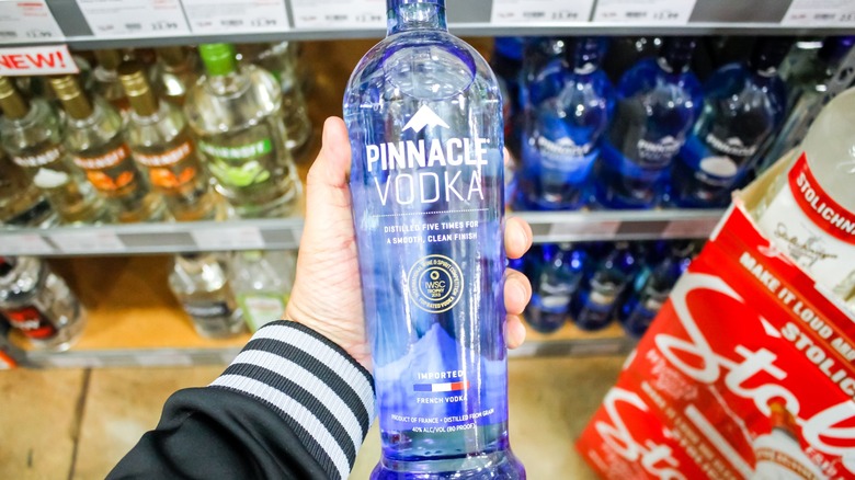 Someone holding a bottle of Pinnacle Vodka.