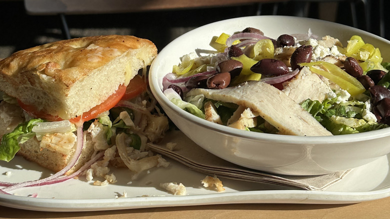 A half greek salad with chicken and a half sandwich from Panera