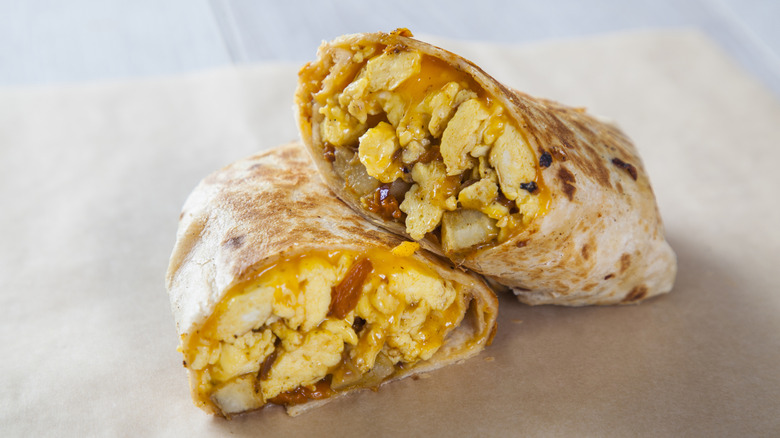 A sliced breakfast burrito with eggs, cheese and potatoes