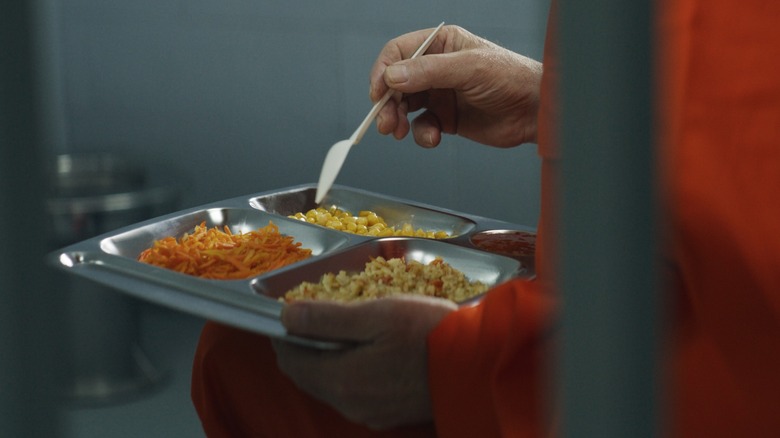 An inmate holding a tray of prison food