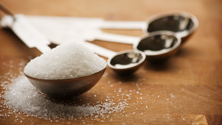 granulated sugar held in spoon