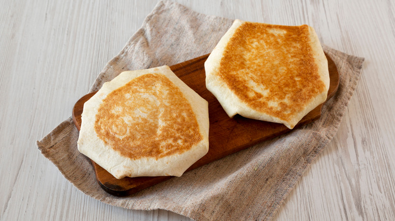 Two crunchwraps resting on a cutting board