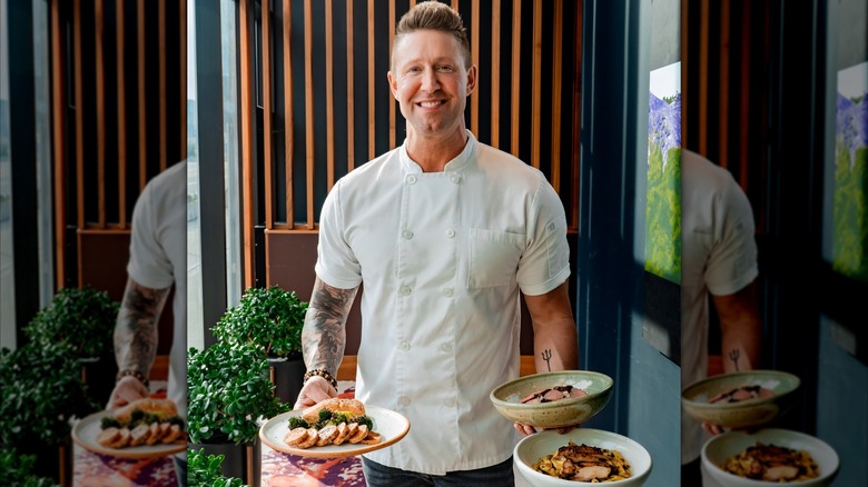 Alex Belew holding meals plates of food