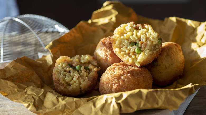 Whole and halved arancini on paper