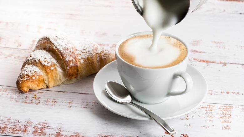 Pouring foam onto cappuccino