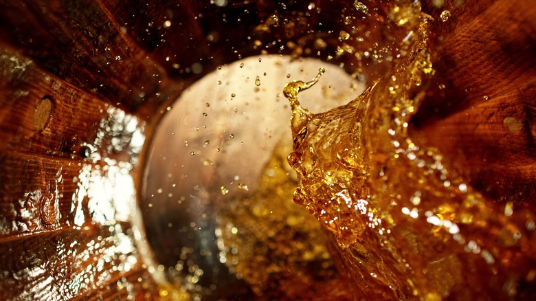 Whisky splashing in wood barrel