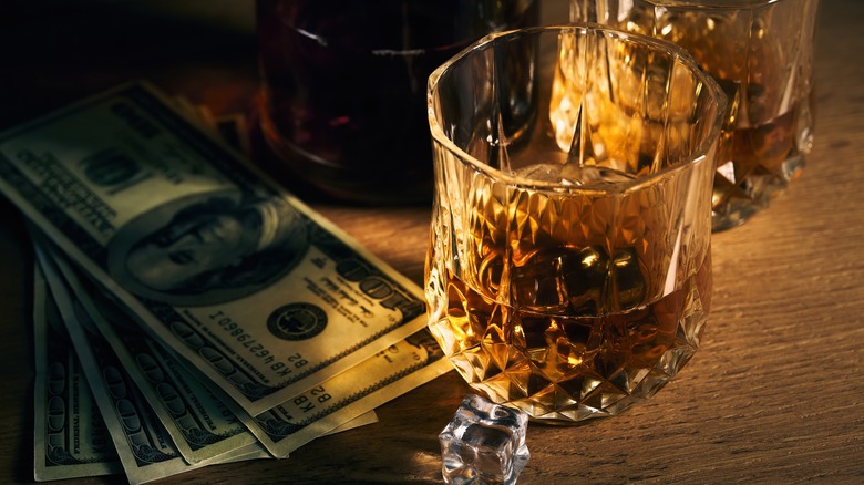 Rocks whisky and hundred dollar bills