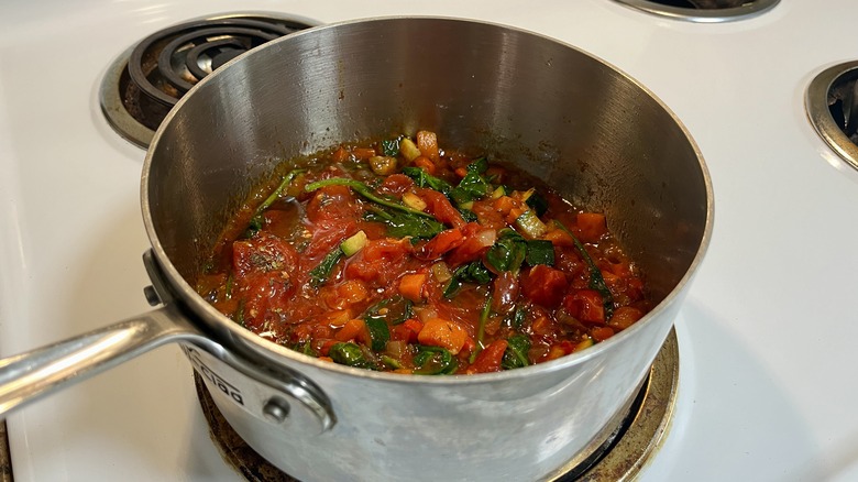 a pot with tomato sauce and vegetables