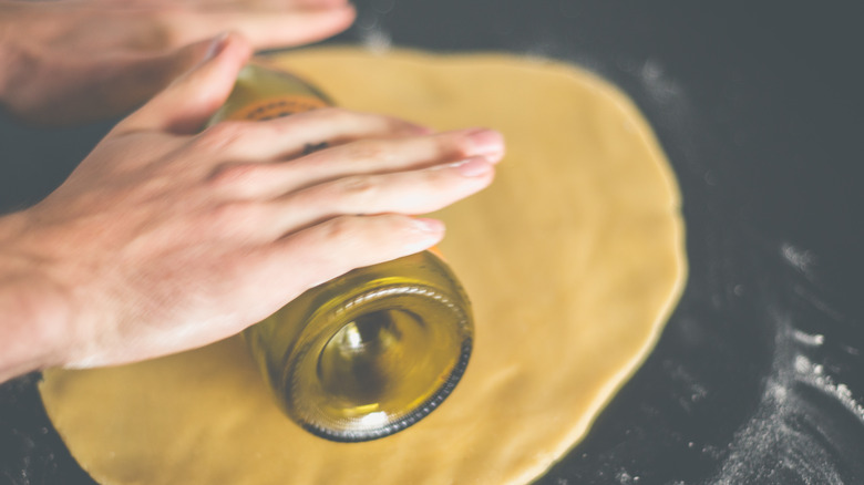 Rolling dough with wine bottle