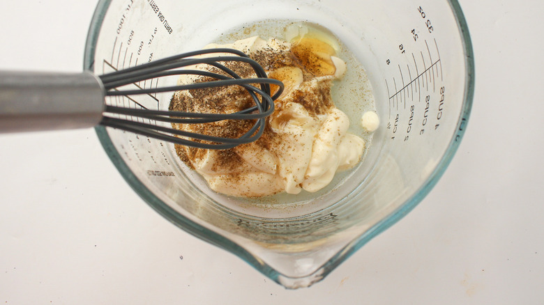 whisking coleslaw ingredients in bowl