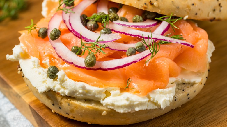 cream cheese on bagel with lox, onion, capers