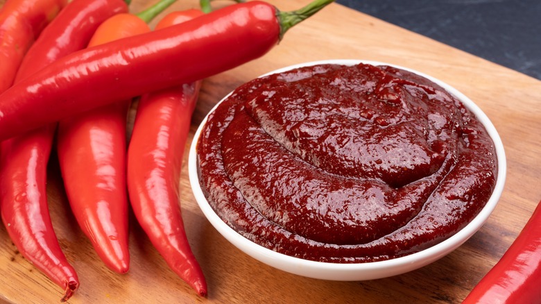 bowl of chili paste next to fresh chilies 