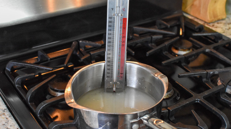 ingredients and thermometer in saucepan
