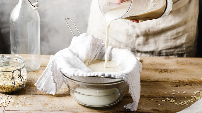 straining oat milk with cheesecloth