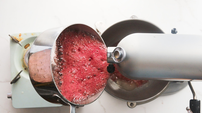 Pouring raspberry syrup into mixer