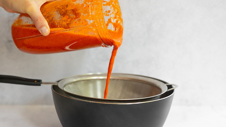 sauce pouring into pot and sieve