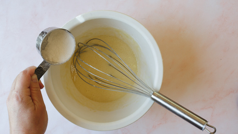 adding flour to batter with whisk
