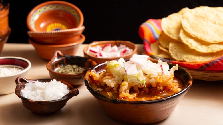 pozole rojo and corn tortillas with garnishes