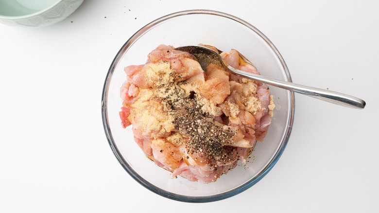 Chicken thigh marinading in bowl 