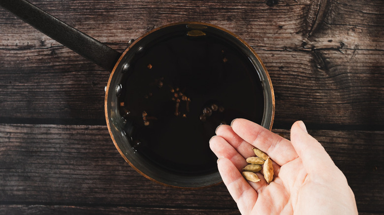 Adding cardamom to pot