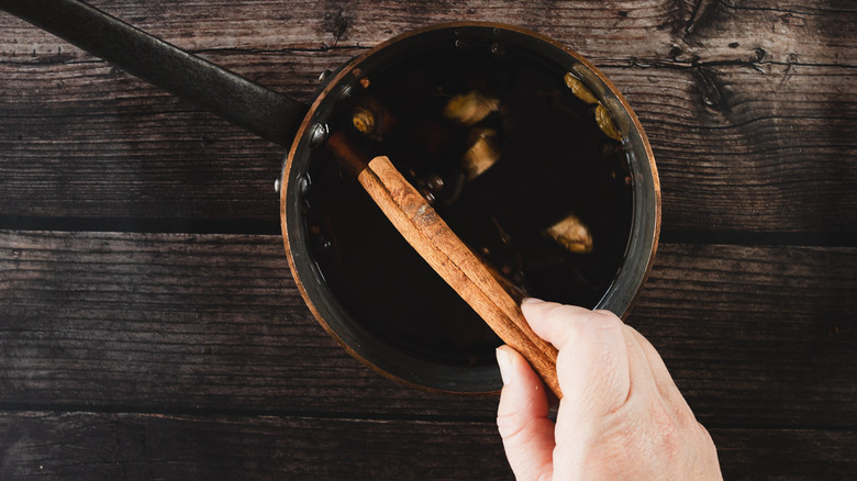 Adding cinnamon to pot