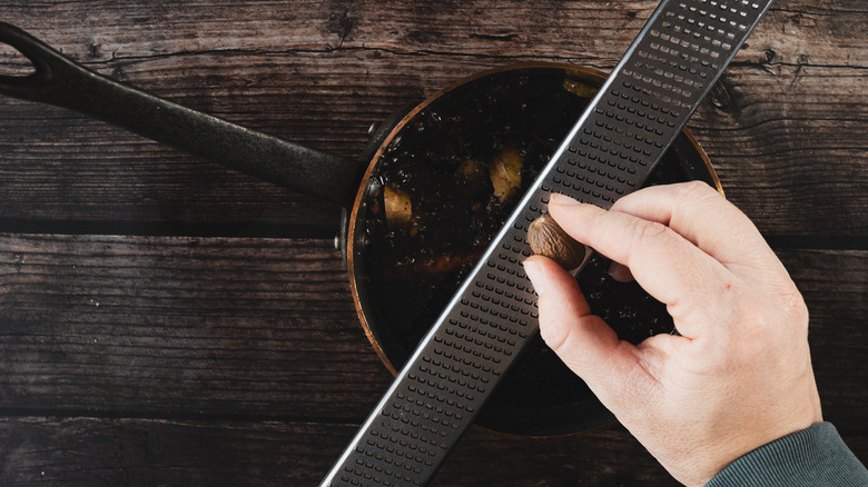 Grating nutmeg into pot