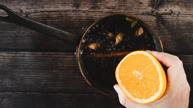 Squeezing orange into saucepan