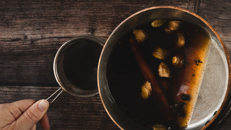 Straining mulled mead into cup