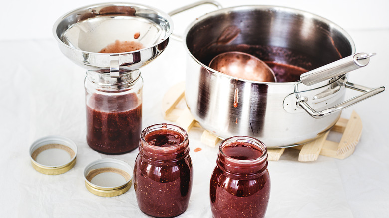 canning raspberry jam, red fruit jam, ladle, funnel, jam jars