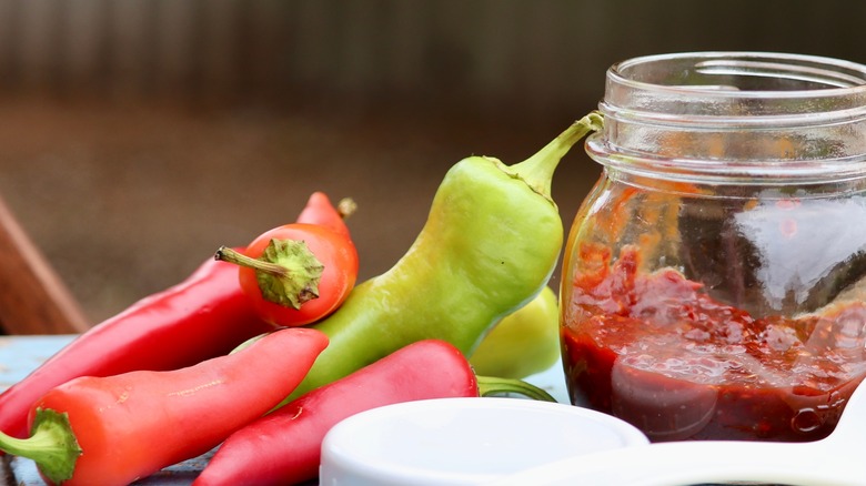 fresh chilies with ground chilies in mason jar