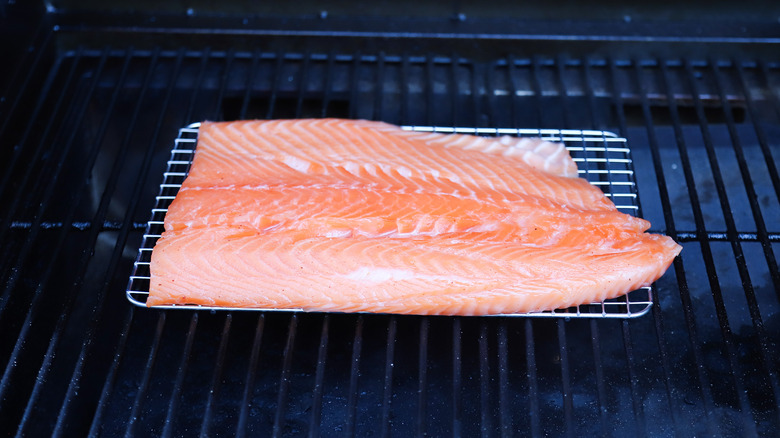 Raw salmon on hot smoker