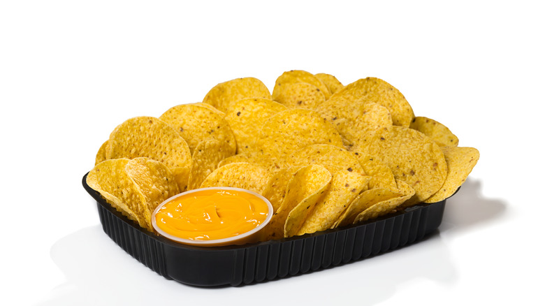 Black plastic tray with chips and nacho cheese