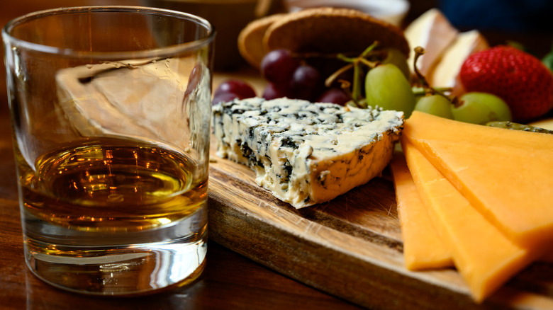 cheese and fruit board and glass of bourbon