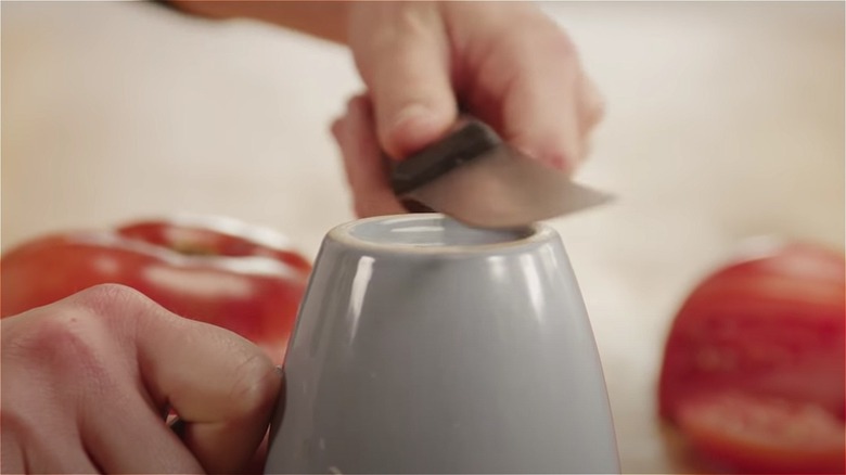 Sharpening knife against coffee mug