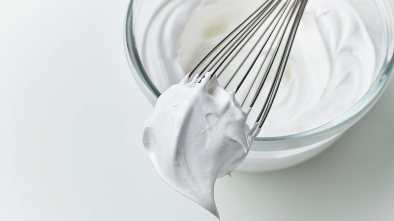 whipped cream in a bowl with whisk
