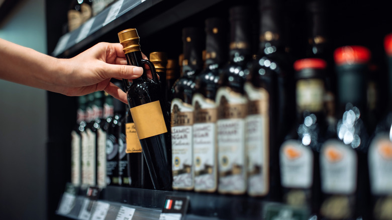 A person choosing a vinegar bottle.