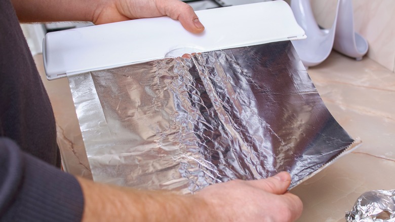 Hands holding aluminum foil