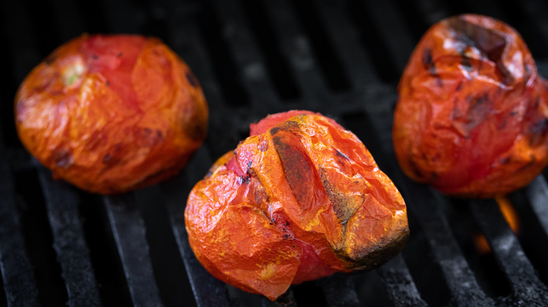 Roma tomatoes cooking on a grill