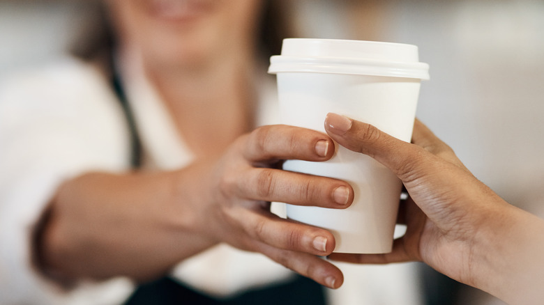 Barista handing cup to customer