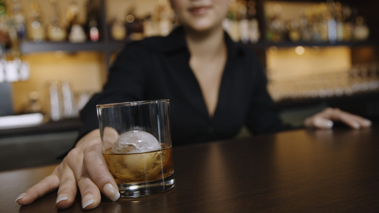 bartender sliding drink across bar