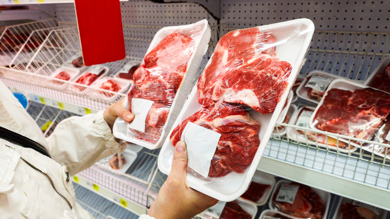 shopper holding two packages of meat